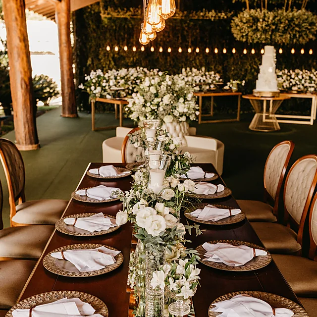 Sophisticated wedding reception table setting with gold tableware and candle centrepieces
